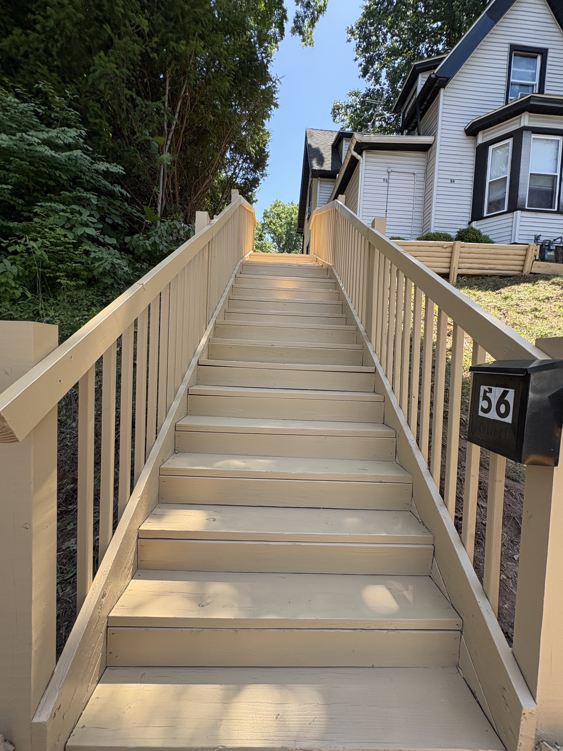 Long finished outdoor wooden stairway with new handrails