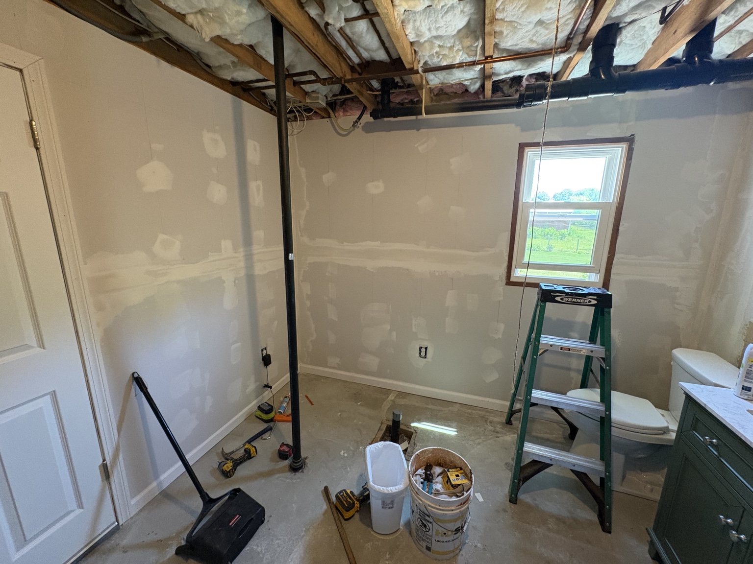 Interior room with newly installed and patched drywall during renovation